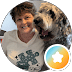 A smiling woman with short hair stands next to a fluffy, speckled dog; a star icon overlays the bottom right.